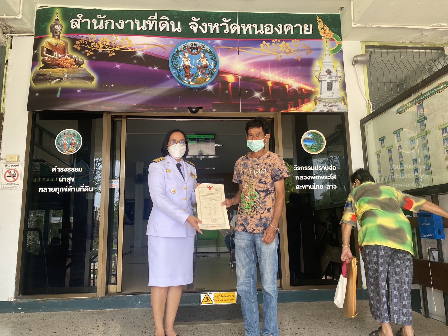 นายประพันธ์ คำบาง ปฏิรูปที่ดินจังหวัดหนองคาย มอบหมายให้ นางสาววิจิตร ประจิมทิศ นักวิชาการปฏิรูปที่ดินชำนาญการพิเศษ มอบโฉนดที่ดินเอกชนให้แก่เกษตรกร เมืองหนองคาย,อำเภอท่าบ่อ จังหวัดหนองคาย จำนวน 5 ราย