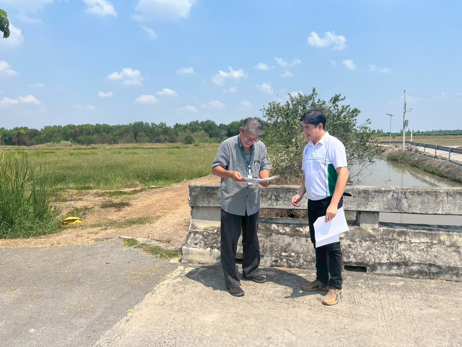 title - นายจักรพงศ์ วรเสฏฐ์ฐากูร นายช่างสำรวจอาวุโส และผู้ช่วยนายช่างสำรวจ ร่วมกับช่างรังวัด สำนักงานที่ดินจังหวัดปทุมธานี สาขาธัญบุรี และเจ้าของแปลงที่ดิน ระวังชี้แนวเขตที่ดินติดกับแนวเขตปฏิรูปที่ดิน ที่ดินตั้งอยู่ตำบลบึงบา อำเภอหนองเสือ จังหวัดปทุมธานี 