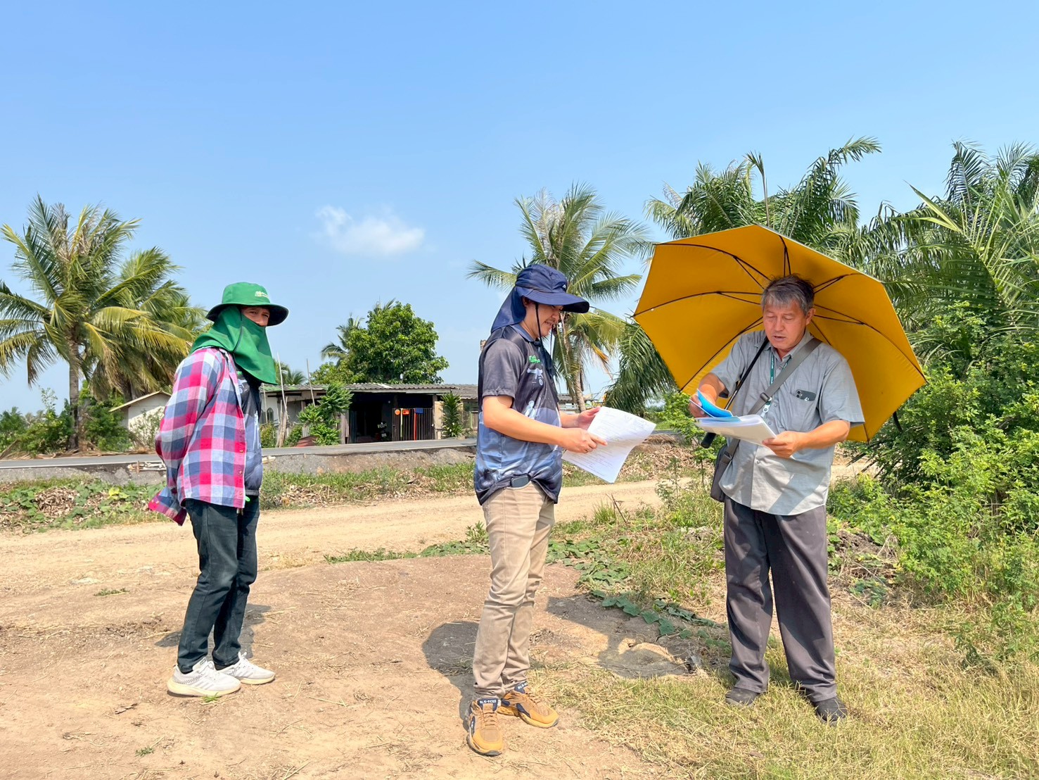 title - นายจักรพงศ์ วรเสฏฐ์ฐากูร นายช่างสำรวจอาวุโส และผู้ช่วยนายช่างสำรวจ ระวังชี้แนวเขตที่ดิน  ร่วมกับช่างรังวัด สำนักงานที่ดินจังหวัดปทุมธานี สาขาธัญบุรี และเจ้าของแปลงที่ดิน